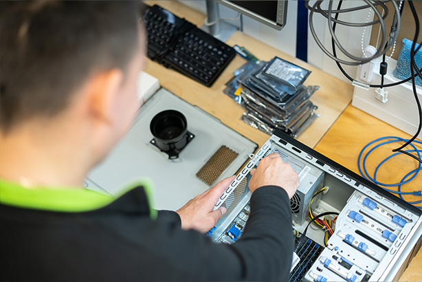 Mitarbeiter repariert einen gebrauchten Laptop für die Wiedervermarktung.